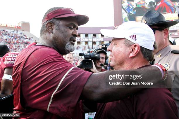 Interim Head Coach Odell Haggins of the Florida State Seminoles meets with Head Coach Matt Viator of the Louisiana Monroe Warhawks at mid-field after...