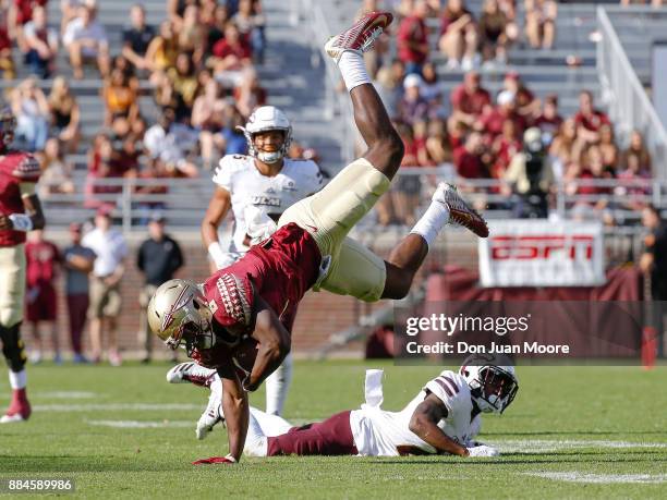 Tight End Tre' McKitty of the Florida State Seminoles is tackled and flipped by Defensive Back Corey Straughter of the Louisiana Monroe Warhawks...