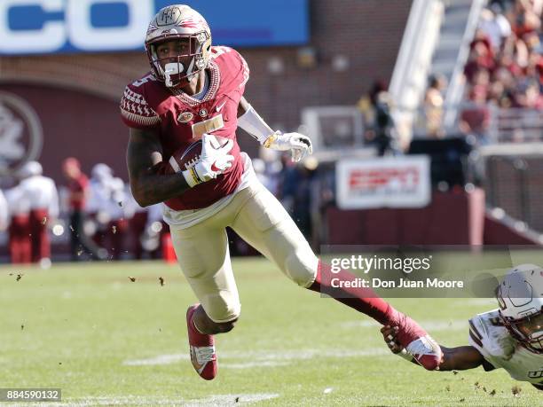 Wide Receiver Ermon Lane of the Florida State Seminoles is shoe stringed tackled by Cornerback Marcus Hubbard of the Louisiana Monroe Warhawks at...