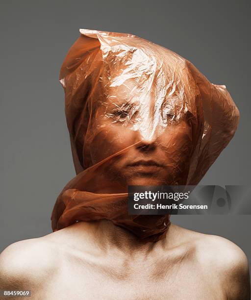 young woman with plastic bag over her head - suffocated stock-fotos und bilder