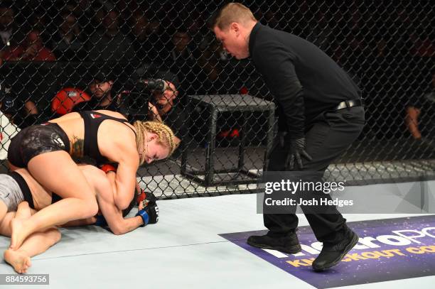 Amanda Cooper attempts to submit Angela Magana as referee Keith Peterson monitors in their women's strawweight bout during the UFC 218 event inside...