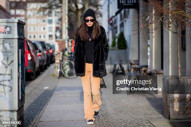 Nadia Ali wearing a black beanie Drykorn, black sunglasses Mango, black jacket Zara, black turtleneck Repeat Cashmere, beige pants The Cords, black...