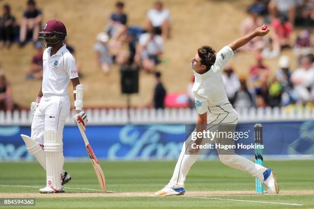 Colin de Grandhomme of New Zealand bowls while Kraigg Brathwaite of the West Indies looks on during day three of the Test match series between New...