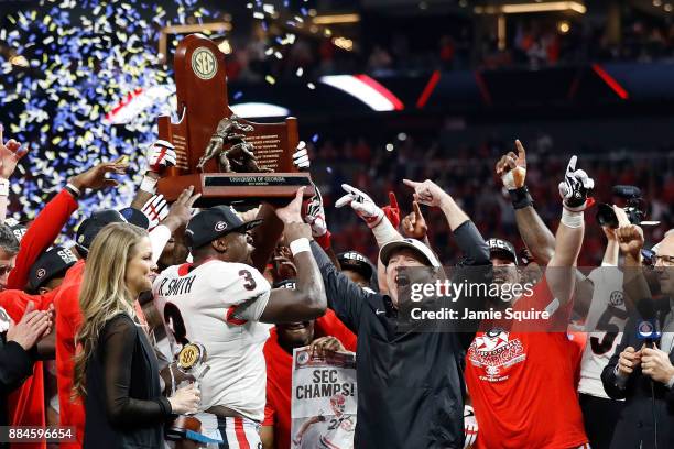 Head coach Kirby Smart of the Georgia Bulldogs, Roquan Smith and the team celebrate with the SEC Championship Trophy after beating Auburn Tigers in...