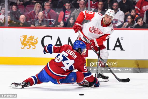 Trevor Daley of the Detroit Red Wings plays the puck past Charles Hudon of the Montreal Canadiens during the NHL game at the Bell Centre on December...