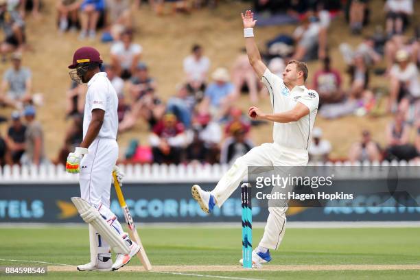 Neil Wagner of New Zealand bowls while Kieran Powell of the West Indies looks on during day three of the Test match series between New Zealand...