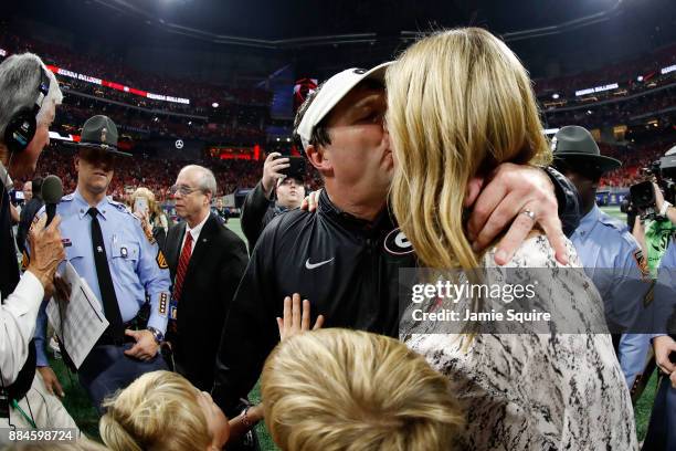 Head coach Kirby Smart of the Georgia Bulldogs celebrates with his wife, Mary Beth Lycett, after beating the Auburn Tigers in the SEC Championship at...