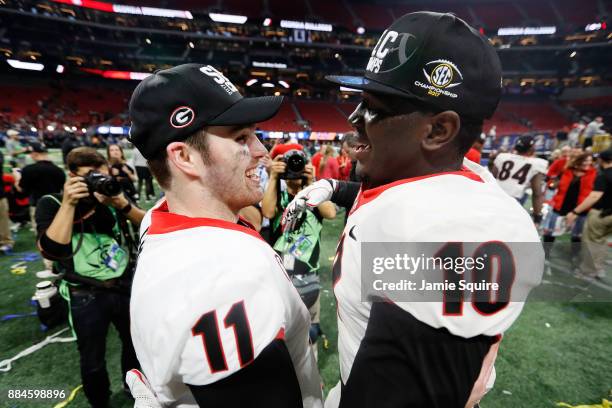 Jake Fromm and Malik Herring of the Georgia Bulldogs celebrate beating the Auburn Tigers in the SEC Championship at Mercedes-Benz Stadium on December...