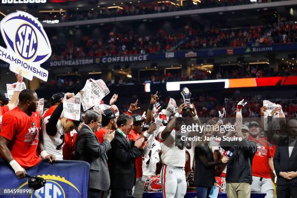 Roquan Smith of the Georgia Bulldogs reacts to winning the game MVP trophy after beating the Auburn Tigers in the SEC Championship at Mercedes-Benz...