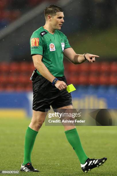 Referee Shaun Evans hands out a yellow card during the round nine A-League match between the Newcastle Jets and Melbourne City at McDonald Jones...