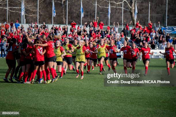 Teammates rush goalie Ana Dilkes of Central Missouri after blocking a penalty kick and defeating Carson-Newman in penalty kicks to win the Division...