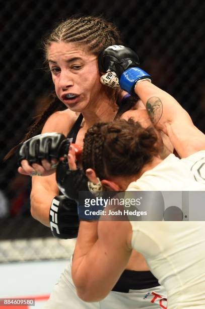 Michelle Waterson punches Tecia Torres in their women's strawweight bout during the UFC 218 event inside Little Caesars Arena on December 02, 2017 in...