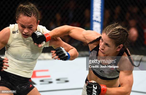 Tecia Torres punches Michelle Waterson in their women's strawweight bout during the UFC 218 event inside Little Caesars Arena on December 02, 2017 in...