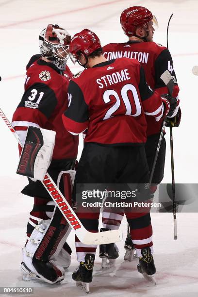 Goaltender Scott Wedgewood of the Arizona Coyotes is congratulated for his shut-out by Dylan Strome following the NHL game against the New Jersey...