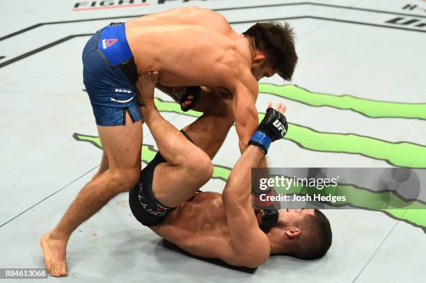 Henry Cejudo punches Sergio Pettis in their flyweight bout during the UFC 218 event inside Little Caesars Arena on December 02, 2017 in Detroit,...