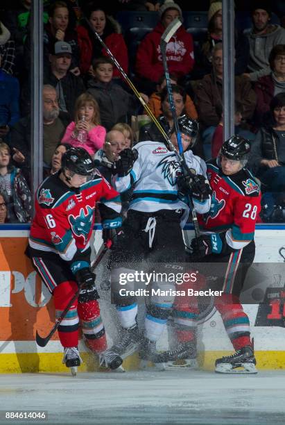 Kole Lind and Leif Mattson of the Kelowna Rockets checks a player of the Kootenay Ice into the boards during second period on December 2, 2017 at...