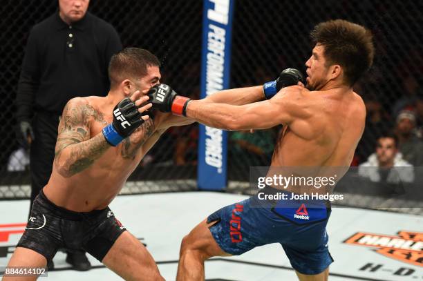 Sergio Pettis punches Henry Cejudo in their flyweight bout during the UFC 218 event inside Little Caesars Arena on December 02, 2017 in Detroit,...