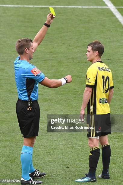 Referee Alex King gives Micheal McGlinchey of the Wellington Phoenix a yellow card during the round nine A-League match between the Wellington...