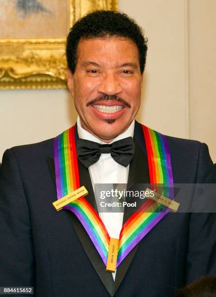 Lionel Richie, one of he five recipients of the 40th Annual Kennedy Center Honors with his award as he poses for a group photo following a dinner...