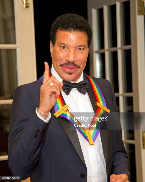 Lionel Richie, one of he five recipients of the 40th Annual Kennedy Center Honors with his award as he poses for a group photo following a dinner...