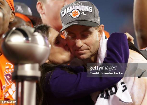 Head coach Dabo Swinney of the Clemson Tigers hugs his wife Kathleen Bassett during the trophy ceremony at the ACC Football Championship at Bank of...