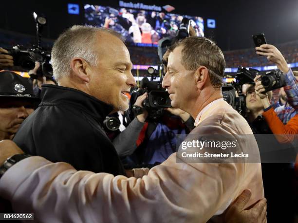 Head coach Dabo Swinney of the Clemson Tigers greets head coach Mark Richt of the Miami Hurricanes on the field after the ACC Football Championship...