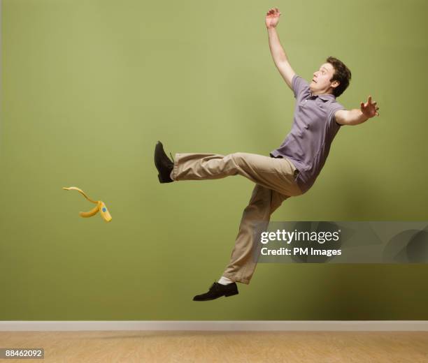 man slipping on banana peel - hinfallen stock-fotos und bilder