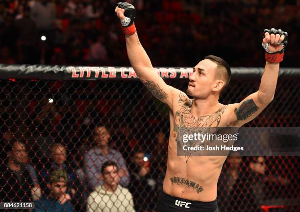 Max Holloway signals to the crowd as he enters the Octagon prior to facing Jose Aldo of Brazil in their UFC featherweight championship bout during...