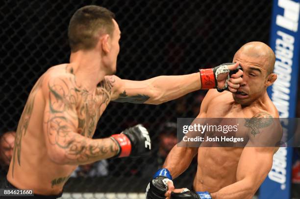 Max Holloway punches Jose Aldo of Brazil in their UFC featherweight championship bout during the UFC 218 event inside Little Caesars Arena on...