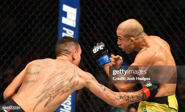 Max Holloway lands a body punch against Jose Aldo of Brazil in their UFC featherweight championship bout during the UFC 218 event inside Little...