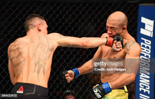 Max Holloway punches Jose Aldo of Brazil in their UFC featherweight championship bout during the UFC 218 event inside Little Caesars Arena on...