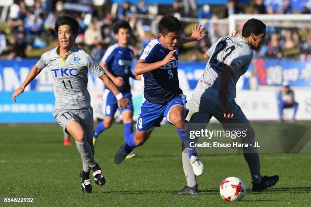 Ryota Nakamura of Azul Claro Numazu competes for the ball against Kenya Okazaki and Mendes of Tochigi SC during the J.League J3 match between Azul...