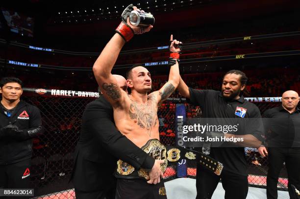 Featherweight champion Max Holloway celebrates after defeating Jose Aldo of Brazil in their UFC featherweight championship bout during the UFC 218...
