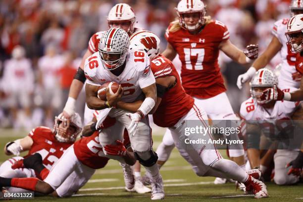 Quarterback J.T. Barrett of the Ohio State Buckeyes is tackled by the Wisconsin Badgers in the fourth quarter during the Big Ten Championship game at...