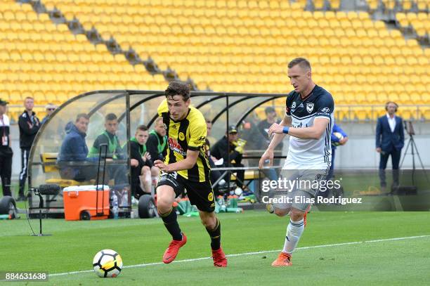 Matthew Ridenton of the Wellington Phoenix makes a run down the sideline with Besart Berisha of Melbourne Victory marking him during the round nine...