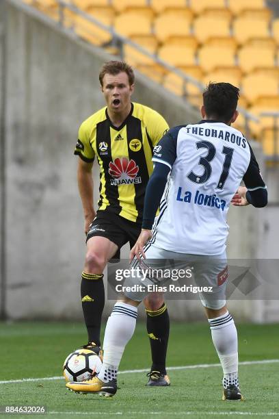 Daniel Mullen of the Wellington Phoenix looks to get past Christian Theoharous of Melbourne Victory during the round nine A-League match between the...