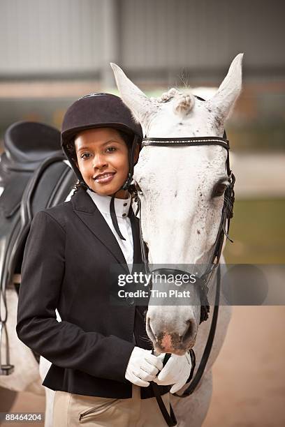 female horse rider standing by horse. - riding hat fotografías e imágenes de stock