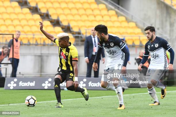 Roy Krishna of the Wellington Phoenix looks to get past Stefan Nigro of Melbourne Victory during the round nine A-League match between the Wellington...