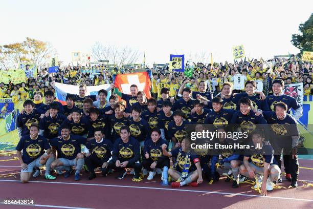 Tochigi SC players and staffs pose for photographs with supporters as they celebrate the promotion to the J2 after the J.League J3 match between Azul...