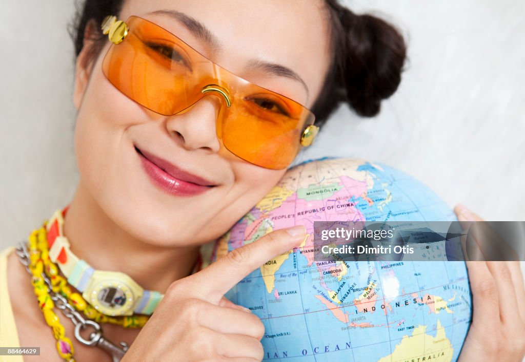  asian woman pointing to china on a globe