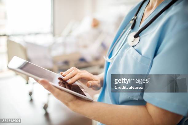 midsection of nurse using tablet pc in hospital - middle stock pictures, royalty-free photos & images