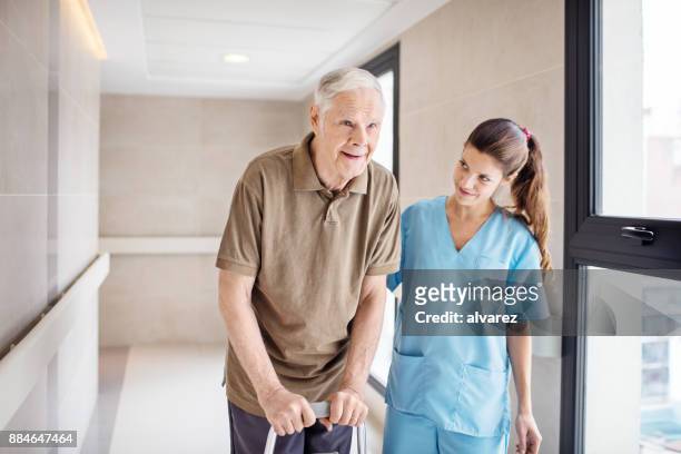 nurse helping senior man in using mobility walker - old trying to look young stock pictures, royalty-free photos & images