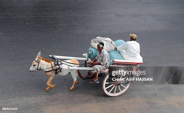 Pakistani man rides his donkey cart during a strike in Karachi on June 13 against the killing of an anti-Taliban cleric in a suicide attack....