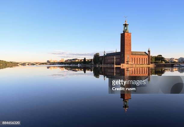 stockholm city hall with reflection on calm water - stockholm stock pictures, royalty-free photos & images