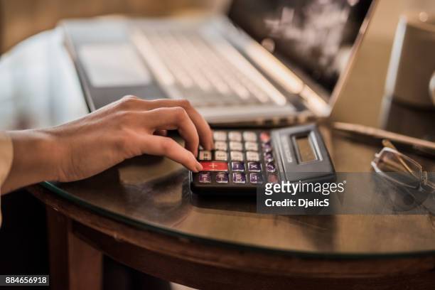 primer plano de mujer joven usando una calculadora. - accountancy fotografías e imágenes de stock