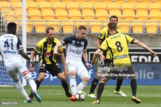 Besart Berisha of Melbourne Victory looks to get past Dario Vidosic and Andrew Durante of the Wellington Phoenix during the round nine A-League match...