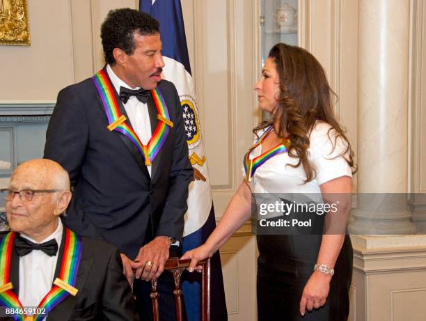 Lionel Richie and Gloria Estefan, two of the five recipients of the 40th Annual Kennedy Center Honors, converse after posing for a group photo...