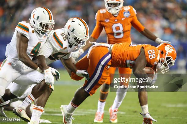 Clemson running back Tavien Feaster is tackled by Miami linebacker Shaquille Quarterman and safety Jaquan Johnson during the game between the Clemson...