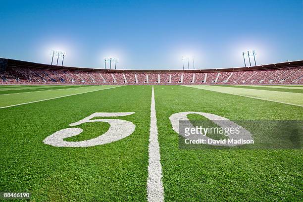 50 yard line on football field in stadium. - american football field stock pictures, royalty-free photos & images