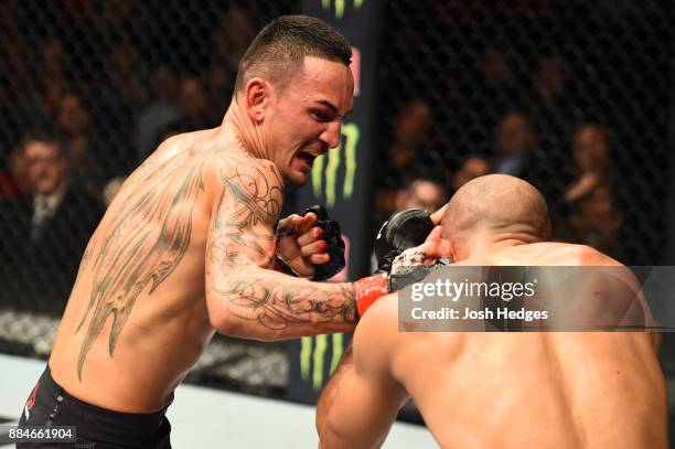 Max Holloway punches Jose Aldo of Brazil in their UFC featherweight championship bout during the UFC 218 event inside Little Caesars Arena on...